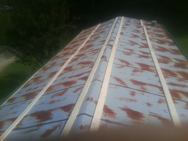 Rusted metal roof panels with new wood purlins before replacement — Storm Damage Roof Repair in Huddleston by Roofing Brothers