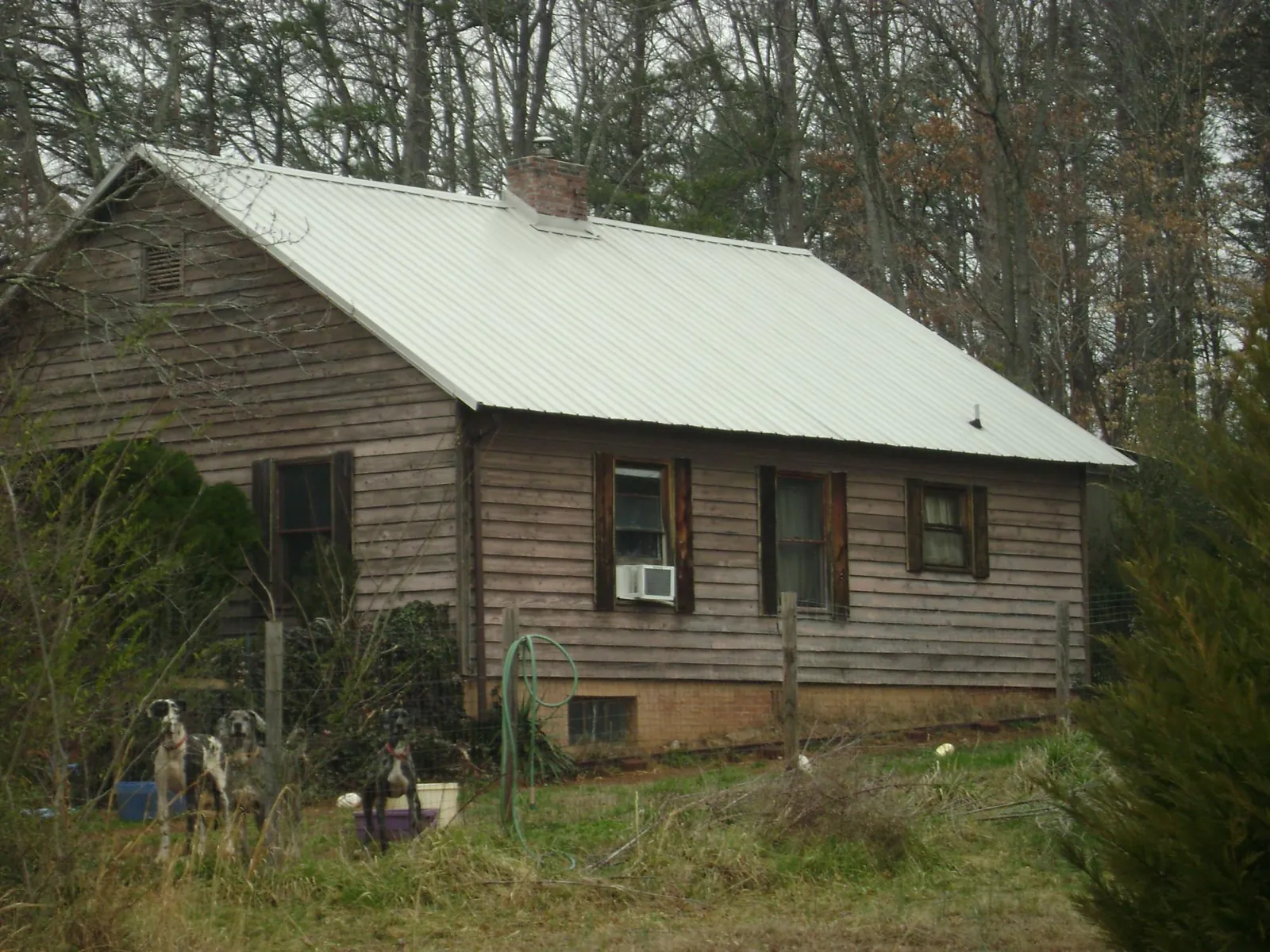 White metal roof on an old wood sided farmhouse, from a Metal Roof Installation job in Huddleston